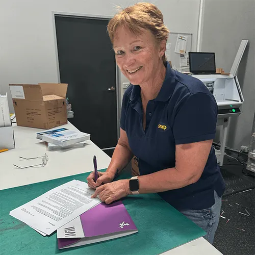 Person holding and signing their Will document