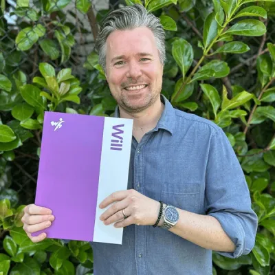 Will Hero customer standing with their completed will folder before travelling